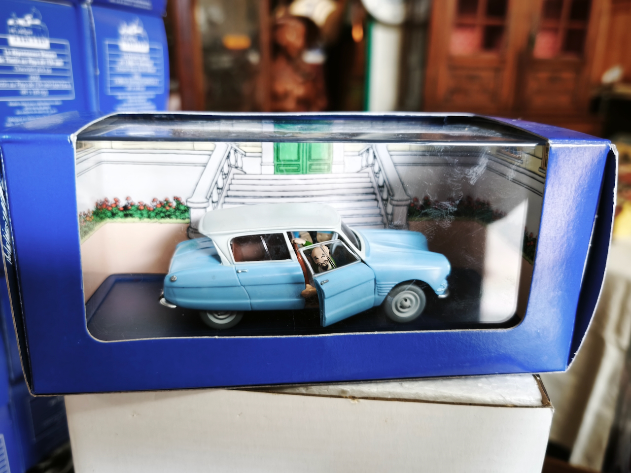 En voiture Tintin échelles 1/43e, éditées par Atlas / Moulinsart dans leurs boîtes bleues d'origine avec décors en fond de boîte – Image 52