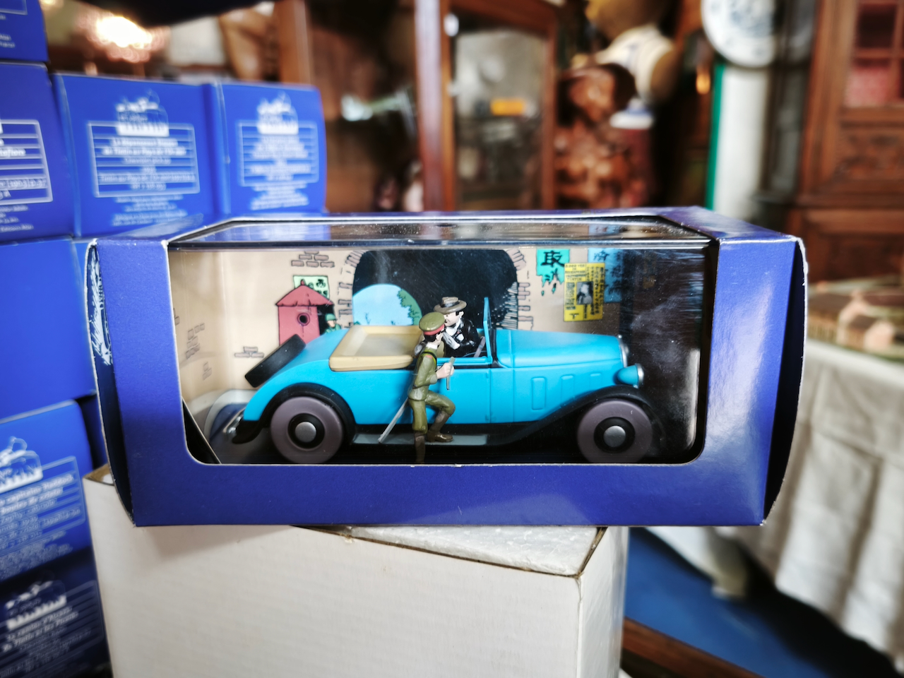 En voiture Tintin échelles 1/43e, éditées par Atlas / Moulinsart dans leurs boîtes bleues d'origine avec décors en fond de boîte – Image 57