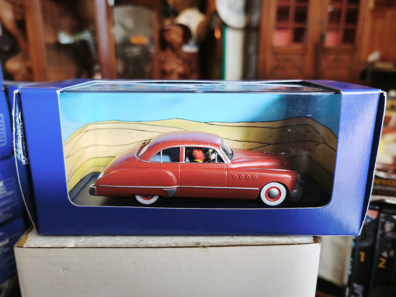 En voiture Tintin échelles 1/43e, éditées par Atlas / Moulinsart dans leurs boîtes bleues d'origine avec décors en fond de boîte – Image 58