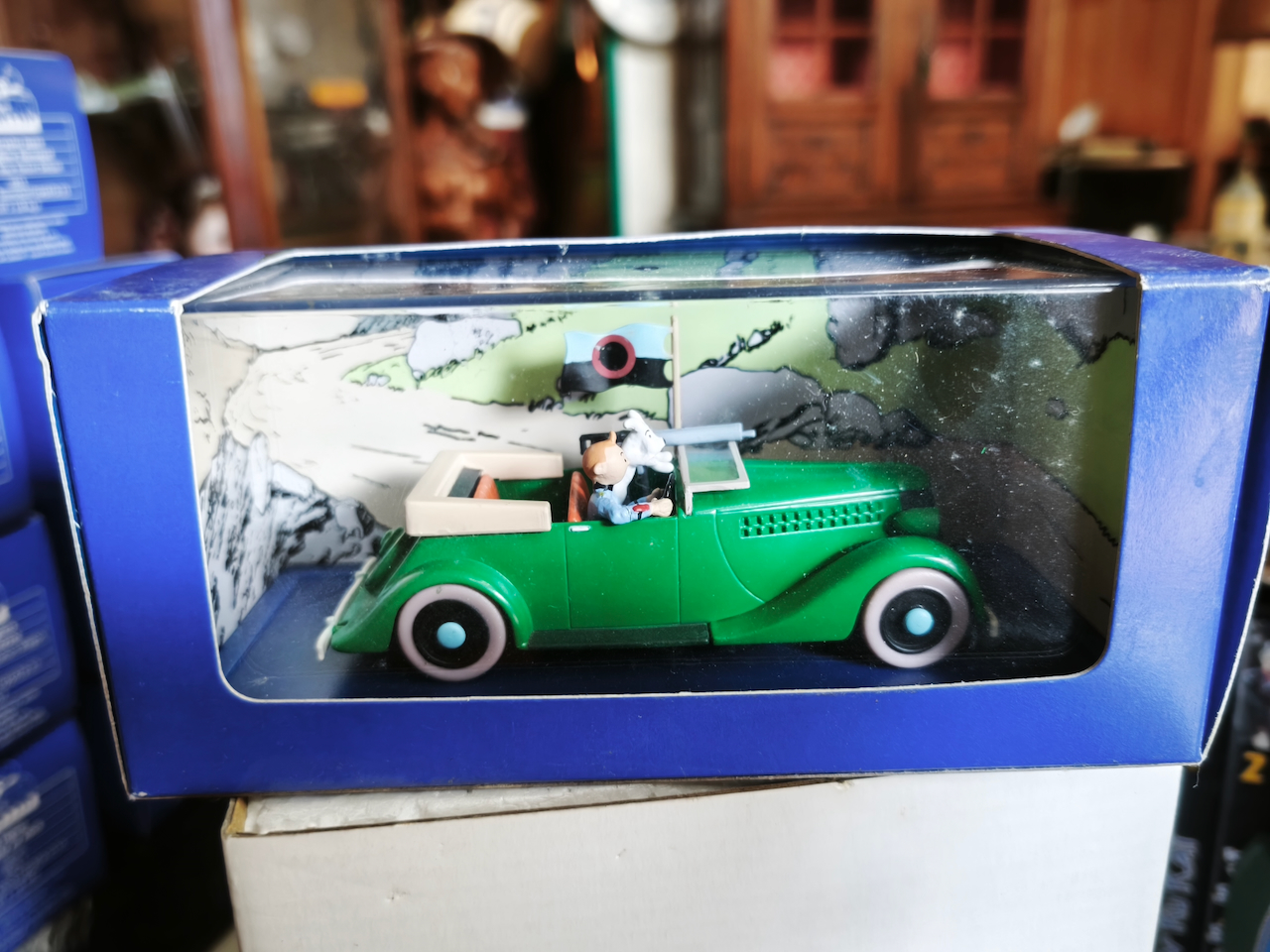 En voiture Tintin échelles 1/43e, éditées par Atlas / Moulinsart dans leurs boîtes bleues d'origine avec décors en fond de boîte – Image 60